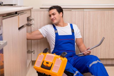 Mutfakta çalışan genç tamirci.