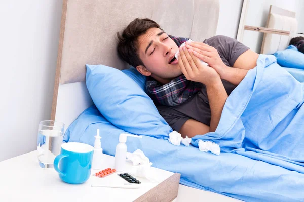 Homem doente com gripe deitado na cama — Fotografia de Stock