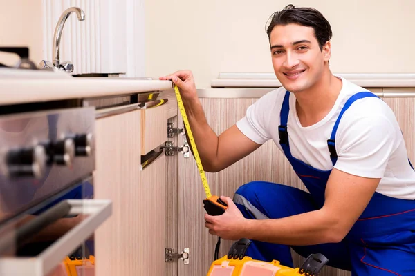 Молодий ремонтник працює на кухні — стокове фото