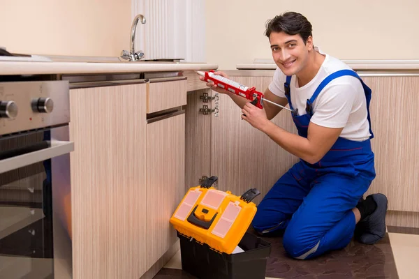 Joven reparador trabajando en la cocina — Foto de Stock