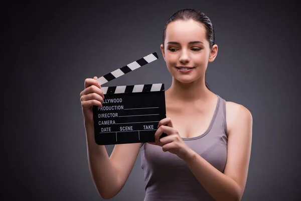 Woman with movie clapper on gray background — Stock Photo, Image