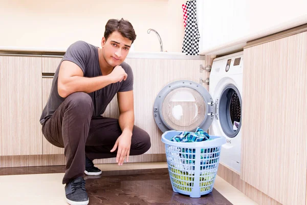 युवा पति आदमी घर पर कपड़े धो रहा है — स्टॉक फ़ोटो, इमेज