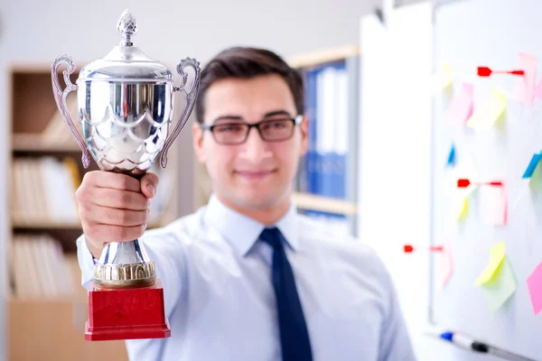 Young businessman receiving prize cup in office — Stock Photo, Image