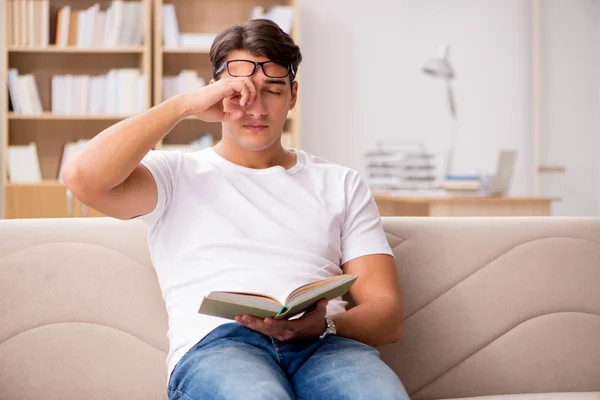 Чоловік читає книгу, сидячи в дивані — стокове фото