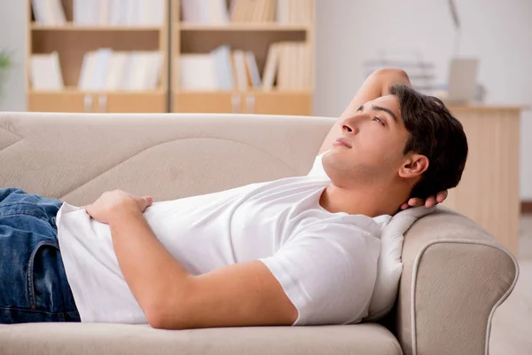 Hombre joven durmiendo en sofá sofá —  Fotos de Stock