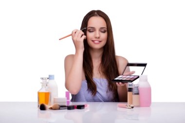 Beyazlar içinde makyaj yapan kadın.