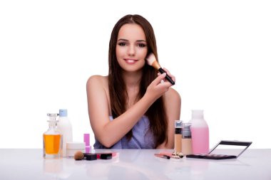 Beyazlar içinde makyaj yapan kadın.