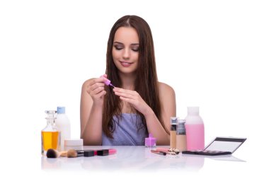 Beyazlar içinde makyaj yapan kadın.