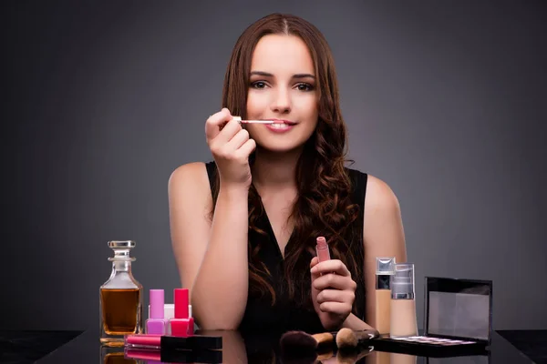 Žena, která dělá make-up na tmavém pozadí — Stock fotografie