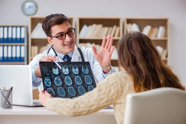 Junger Arzt schaut sich Computertomographie-Röntgenbild an — Stockfoto