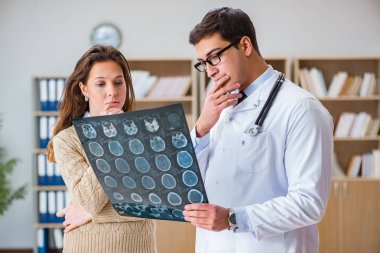 Genç doktor bilgisayardaki röntgen görüntülerine bakıyor.