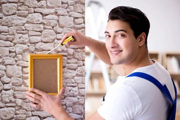 Reparador poner marco de imagen en la pared — Foto de Stock