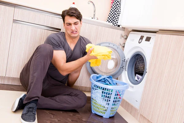 Jeune mari homme faisant la lessive à la maison — Photo