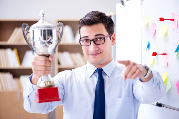 Young businessman receiving prize cup in office — Stock Photo, Image