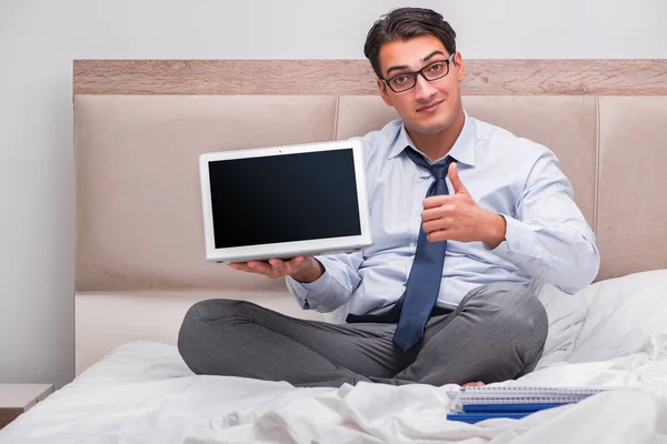 Geschäftsmann arbeitet zu Hause im Bett — Stockfoto