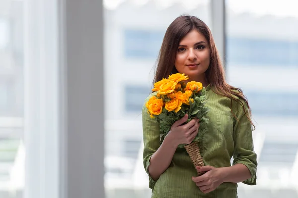 Jong meisje met cadeau van bloemen — Stockfoto