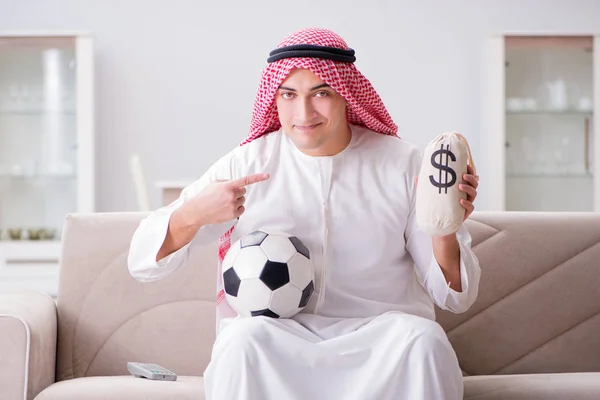 Hombre árabe joven viendo fútbol sentado en el sofá — Foto de Stock