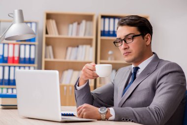 Genç yakışıklı işadamı ofiste çalışıyor.