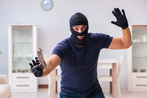 Ladrão usando balaclava roubando coisas valiosas — Fotografia de Stock