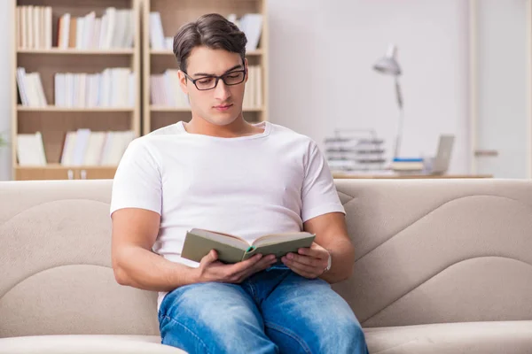 Uomo lettura libro seduto nel divano divano — Foto Stock