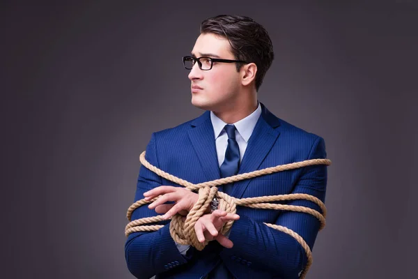 Businessman tied up with rope — 图库照片