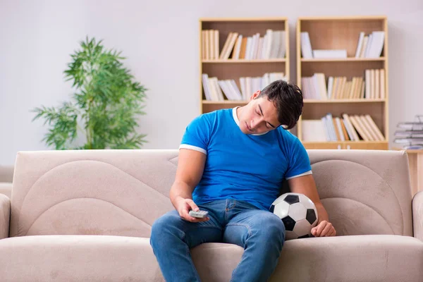 Hombre viendo fútbol en casa sentado en el sofá — Foto de Stock