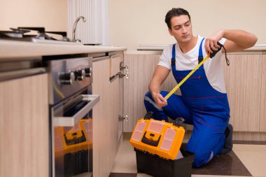 Mutfakta çalışan genç tamirci.