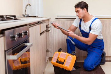 Mutfakta çalışan genç tamirci.