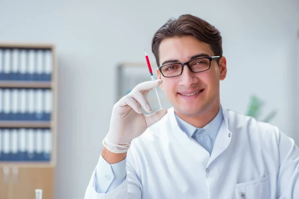 Junger Arzt mit der Spritze — Stockfoto