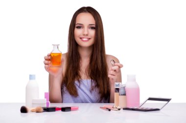 Beyazlar içinde makyaj yapan kadın.