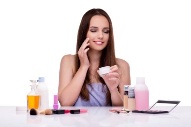 Beyazlar içinde makyaj yapan kadın.