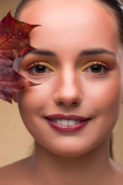 Piękna kobieta się jesienią suchych liści — Zdjęcie stockowe