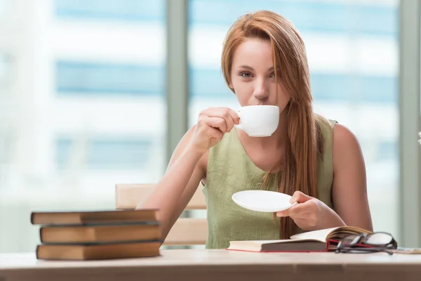 Junge Studentin bereitet sich auf Prüfungen vor und trinkt Tee — Stockfoto