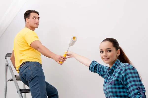 Jeune couple peinture mur à la maison — Photo