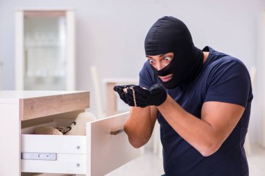 Soyguncu kar maskesi takıp değerli şeyler çalıyor.