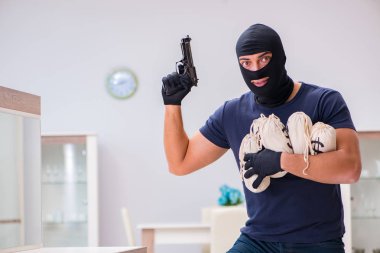 Soyguncu kar maskesi takıp değerli şeyler çalıyor.