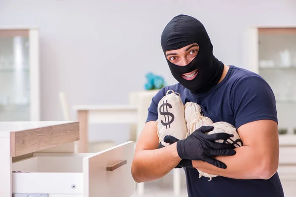 Ladrão usando balaclava roubando coisas valiosas — Fotografia de Stock