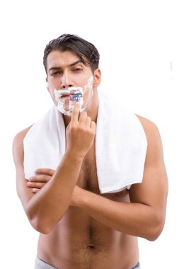 Yakışıklı adam, beyazın üzerinde tek başına tıraş oluyor.