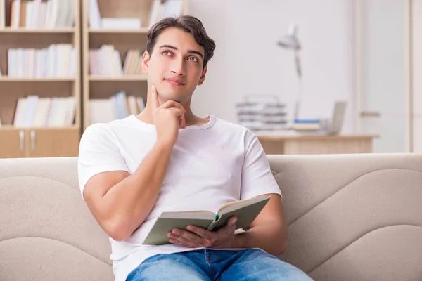 Homme lisant le livre assis dans le canapé — Photo