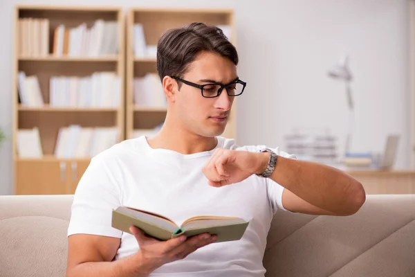 Homem leitura livro sentado no sofá sofá — Fotografia de Stock