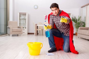 Süper kahraman koca evde yerleri temizliyor.