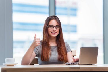 Dizüstü bilgisayarda çalışan genç iş kadını.