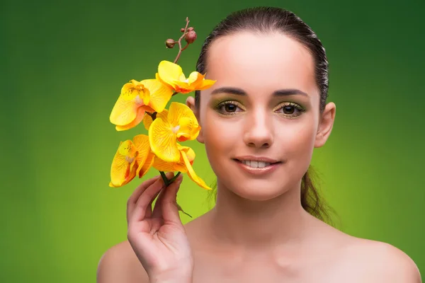 Piękna kobieta z żółtą orchideą kwiat — Zdjęcie stockowe