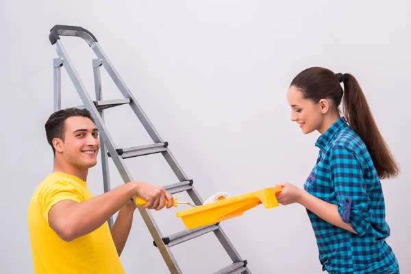 Pareja joven pintando pared en casa — Foto de Stock