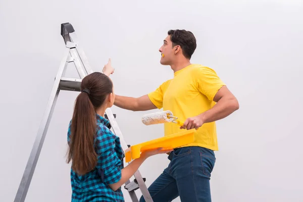 Pareja joven pintando pared en casa — Foto de Stock