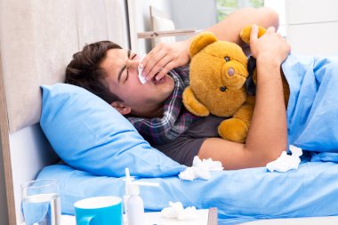 Sick man with flu lying in the bed clipart