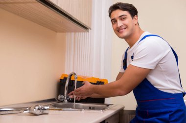 Mutfakta çalışan genç tamirci.