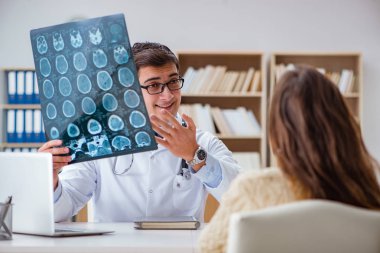 Genç doktor bilgisayardaki röntgen görüntülerine bakıyor.