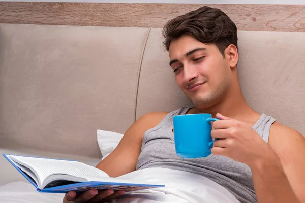 Homem leitura livro na cama — Fotografia de Stock