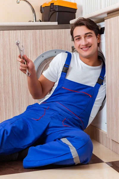 Reparateur repariert Waschmaschine in der Küche — Stockfoto